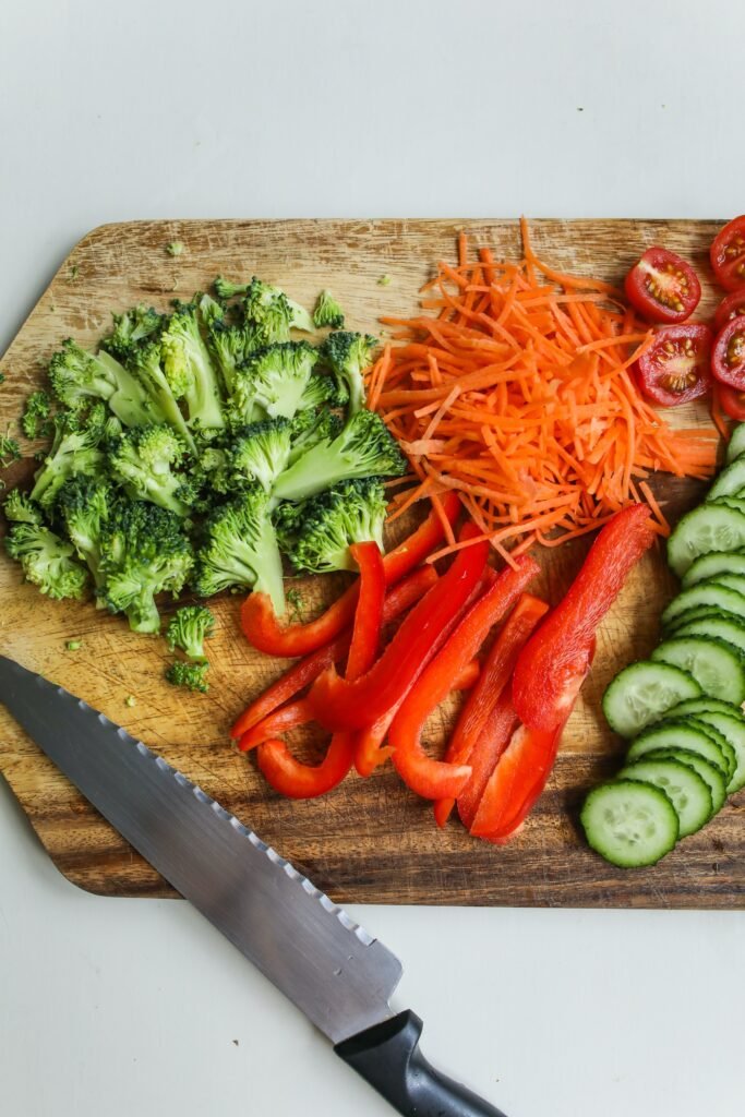 a plate has diet foods of cauliflower, tomato , broccoli , cucumber 